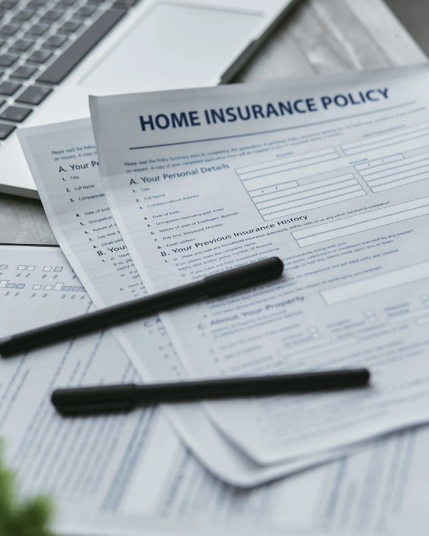 Home insurance policy forms and documents placed on a desk.
